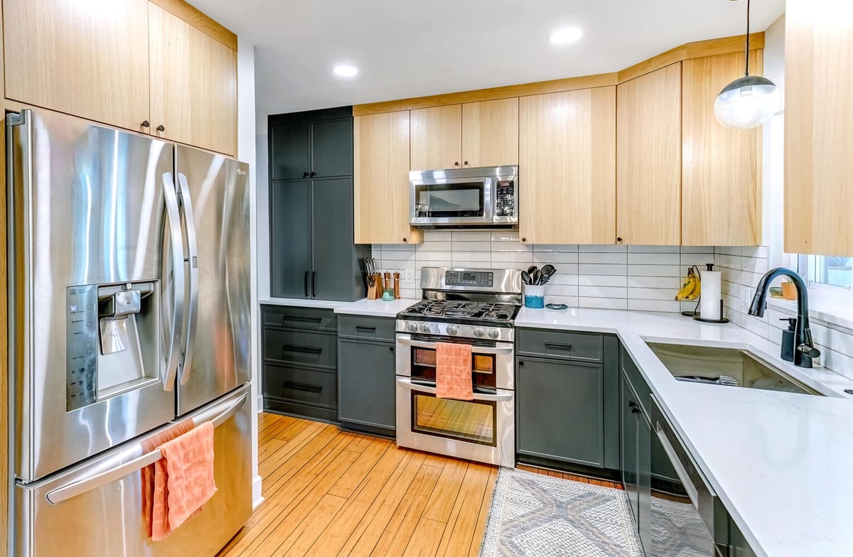 Sleek kitchen design with two-tone cabinetry and natural wood accents by Cabinet Creations in Oakland County, MI
