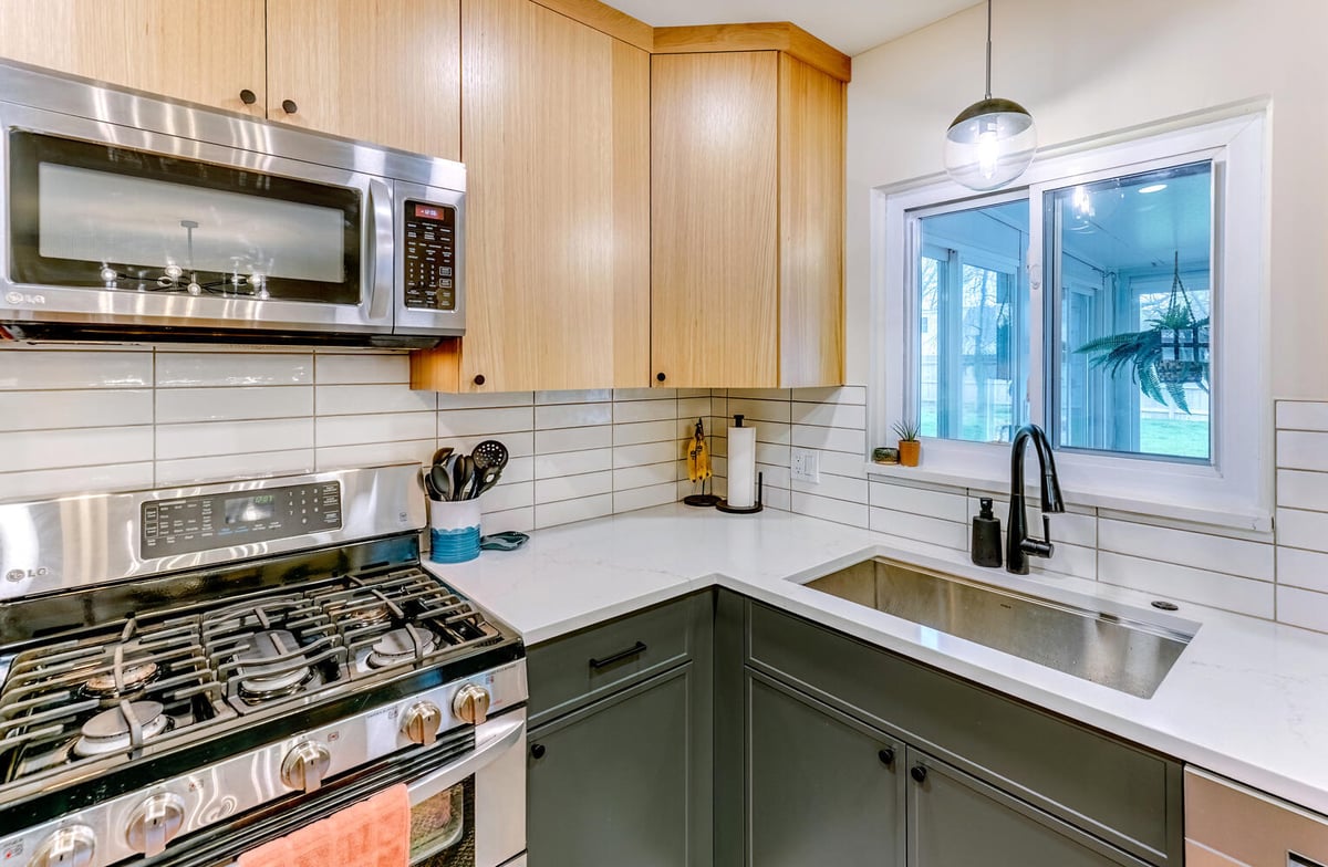 Waterford, MI custom home kitchen featuring corner sink setup and wood cabinetry by Cabinet Creations