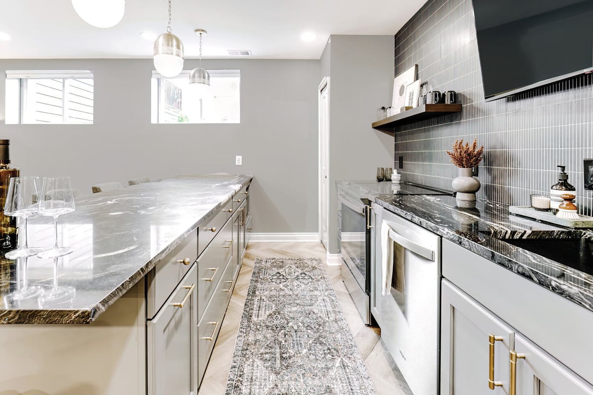 Basement entertaining space in Clarkston, MI custom home by Cabinet Creations featuring large island bar