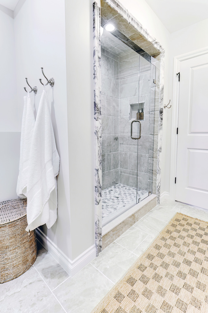 Bright and clean basement bathroom with spa-style shower in Clarkston home by Cabinet Creations