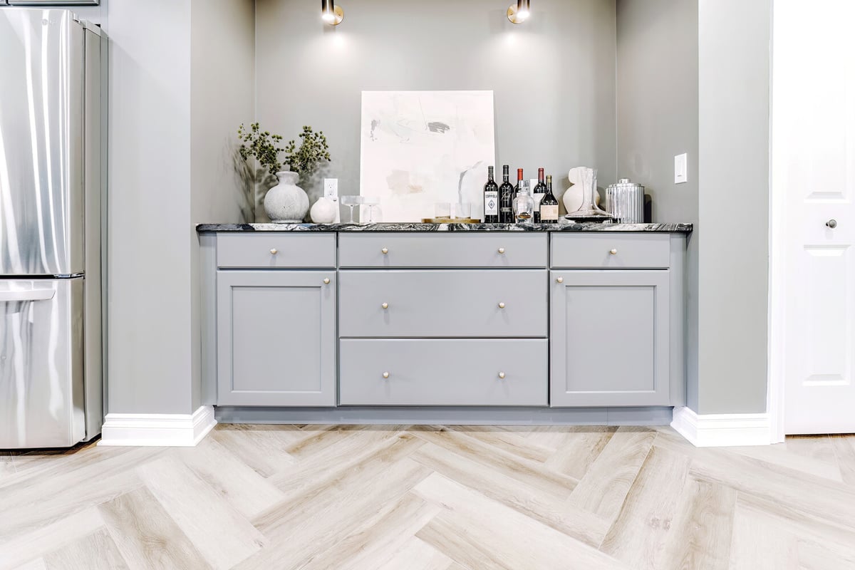 Built-in bar with gray shaker cabinets and marble top in Clarkston custom basement by Cabinet Creations