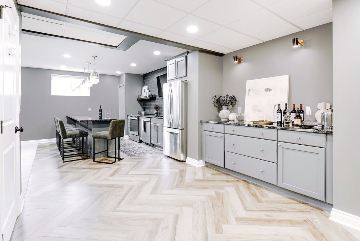 Custom home basement transformation in Clarkston featuring open bar and entertainment zone by Cabinet Creations