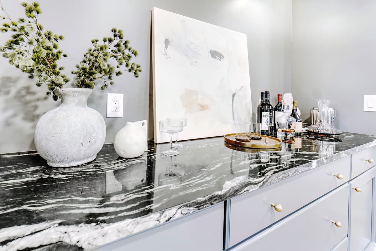 Custom wet bar in Clarkston, MI by Cabinet Creations featuring gray cabinetry and black marble countertops