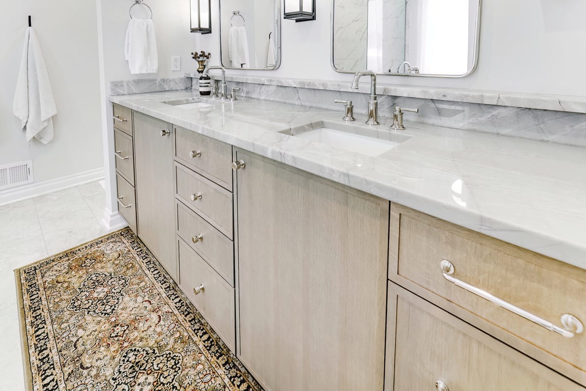 Light wood double vanity with marble countertops in a custom home bathroom by Cabinet Creations in Waterford Township, MI