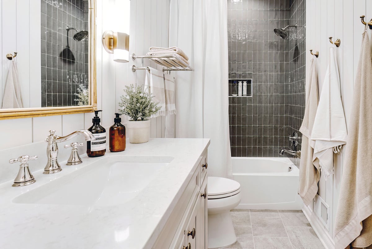 Clarkston bathroom renovation by Cabinet Creations featuring sleek vanity and modern tub-shower with black tile