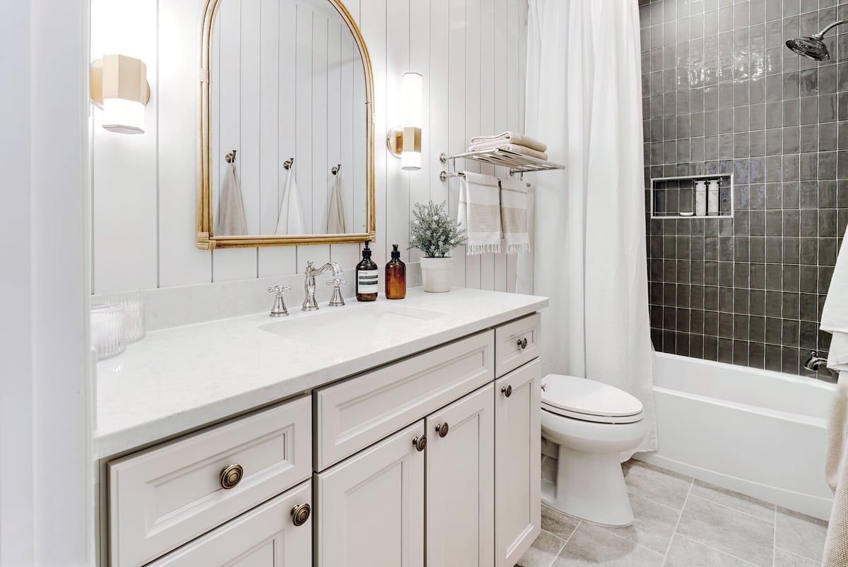 Classic white vanity and black tiled shower in Clarkston bathroom remodel by Cabinet Creations