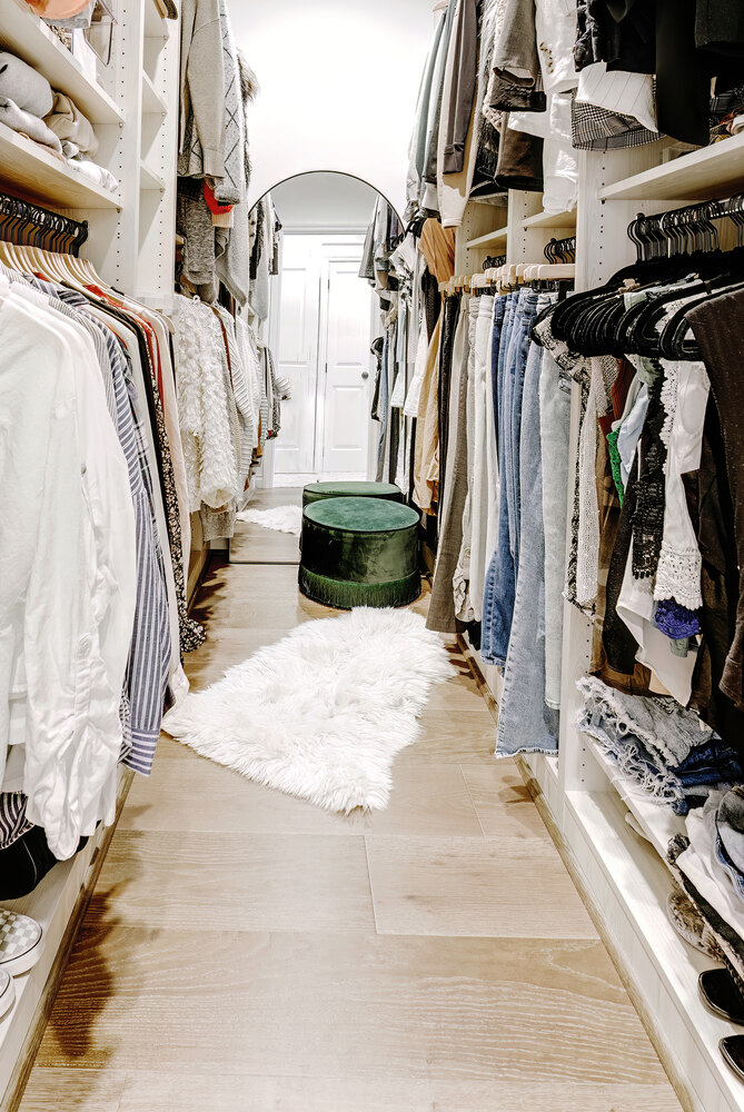 Elegant walk-in closet design with light wood floors and built-in drawers in West Bloomfield Township, MI