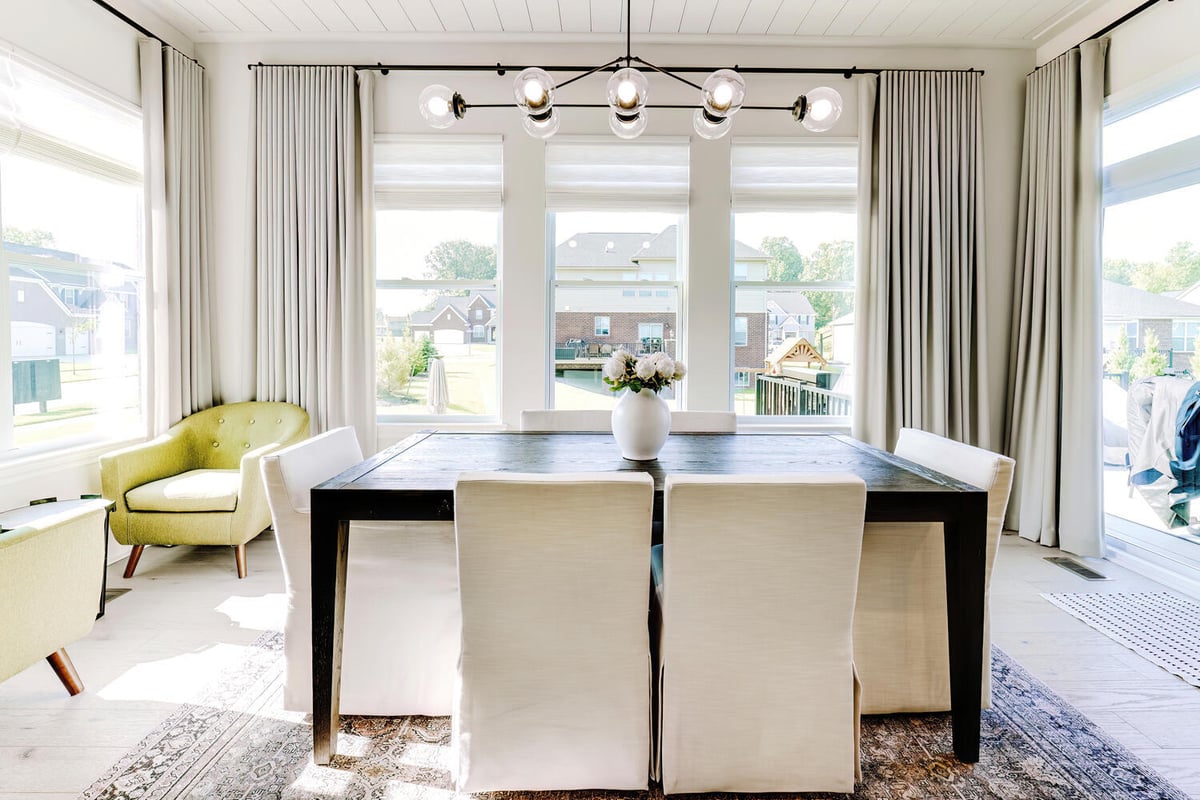 Cozy dining nook with large windows and elegant curtains by Cabinet Creations in Troy, MI