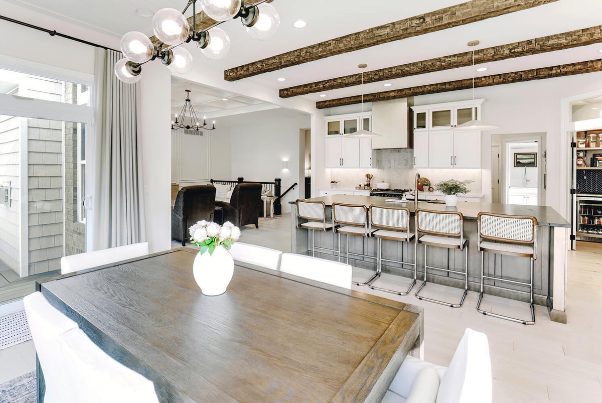 Dining space with exposed wood beams and custom cabinetry by Cabinet Creations in Sylvan Lake, MI