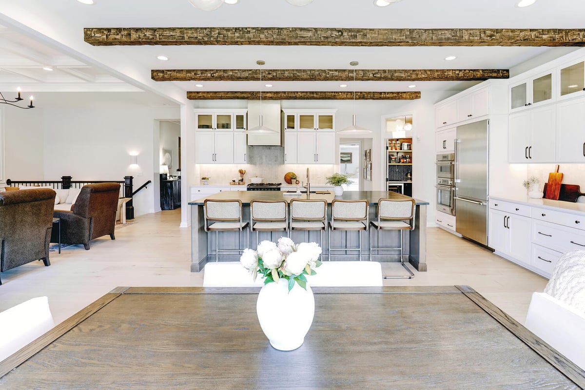 Kitchen island with bar seating next to wood dining table in Keego Harbor, MI custom home