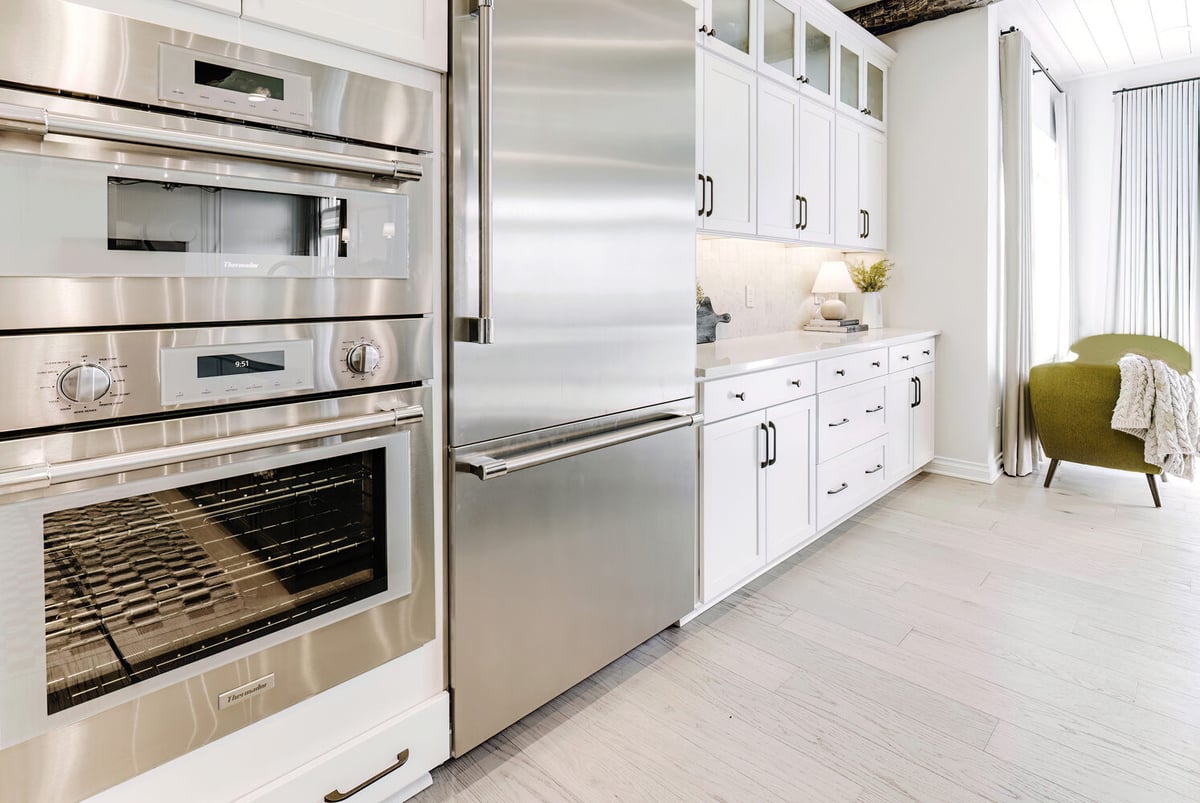 Built-in double oven and fridge wall with ample storage by Cabinet Creations in Orchard Lake, MI