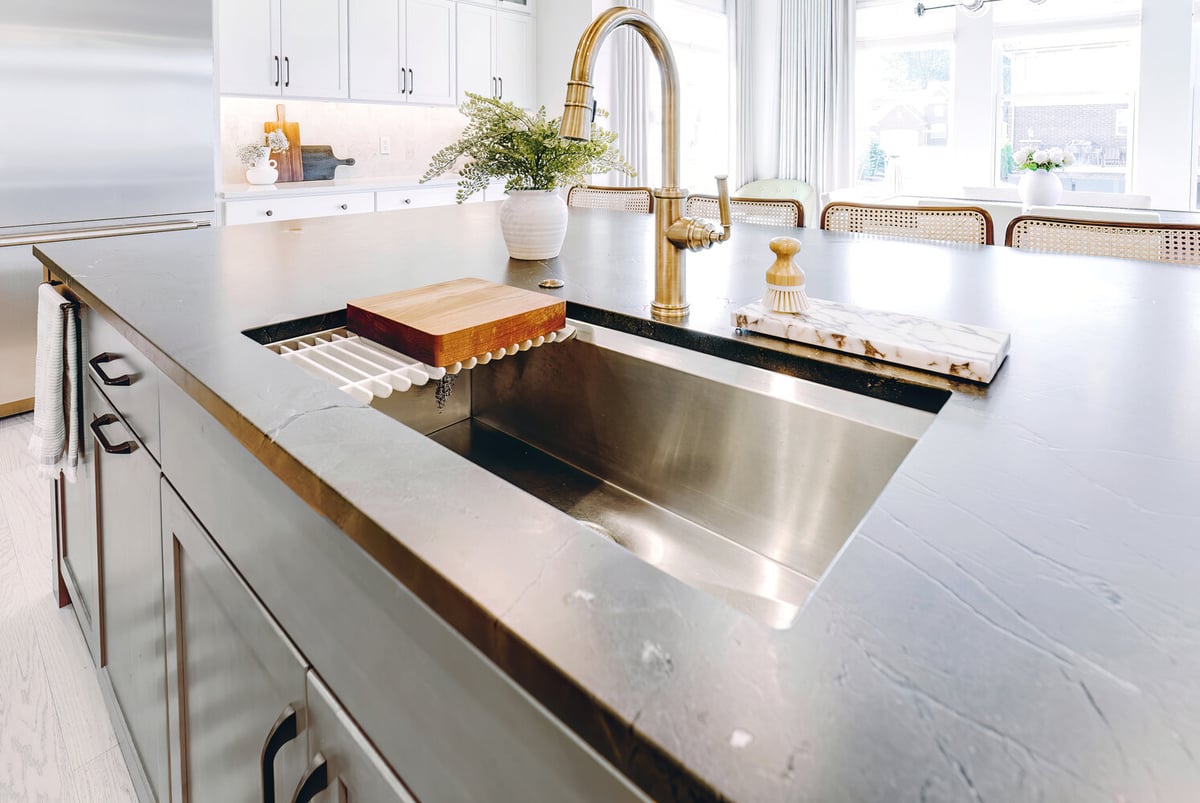 Close-up of island sink and brass faucet in a custom kitchen by Cabinet Creations in Oakland County, MI