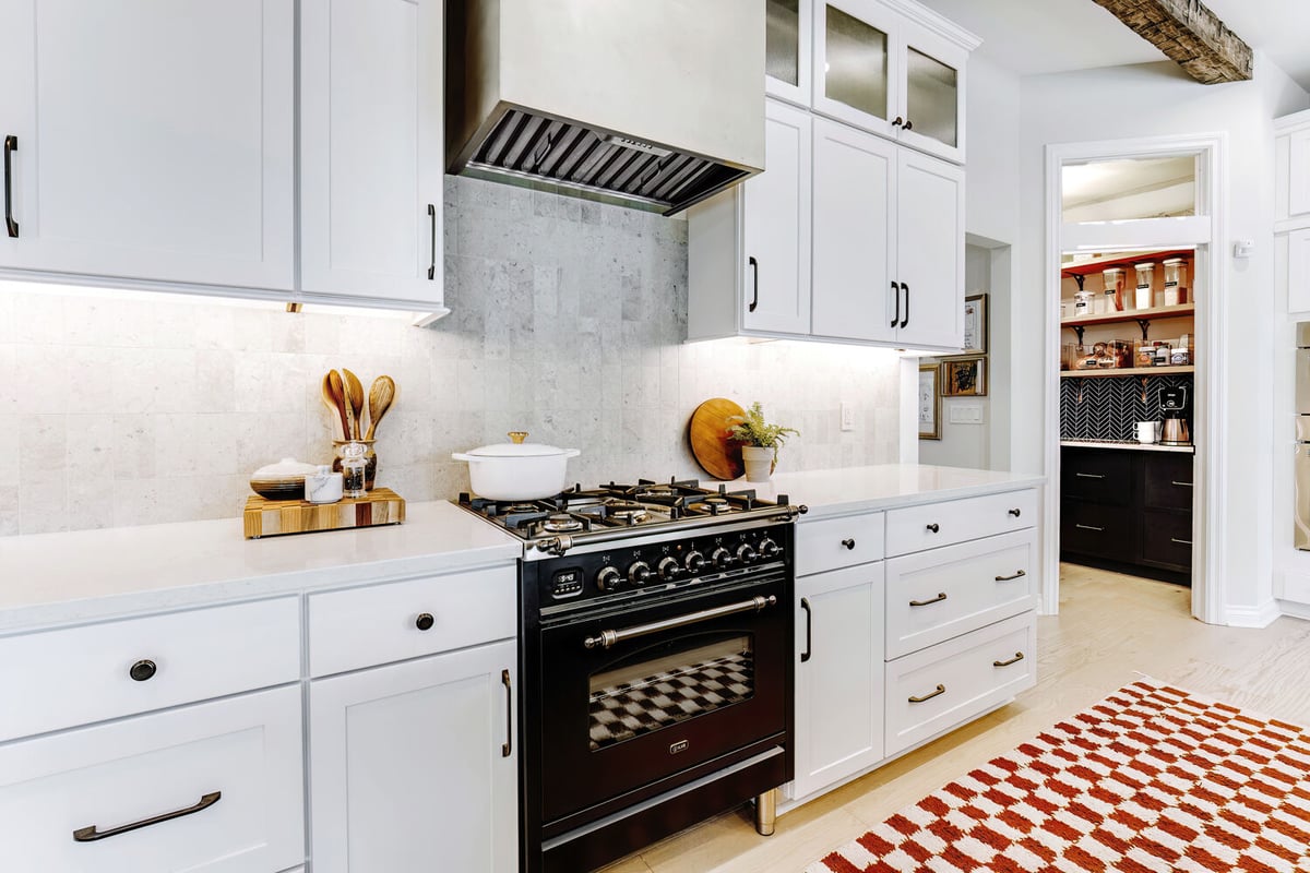Kitchen interior featuring black range and white cabinetry by Cabinet Creations in Troy, MI