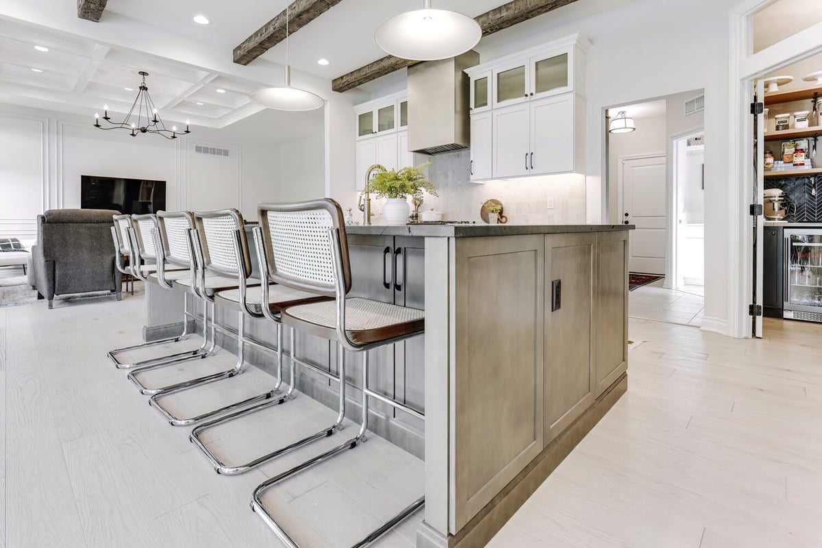 Large kitchen island with chrome bar stools and open-concept living space in Lake Angelus, MI