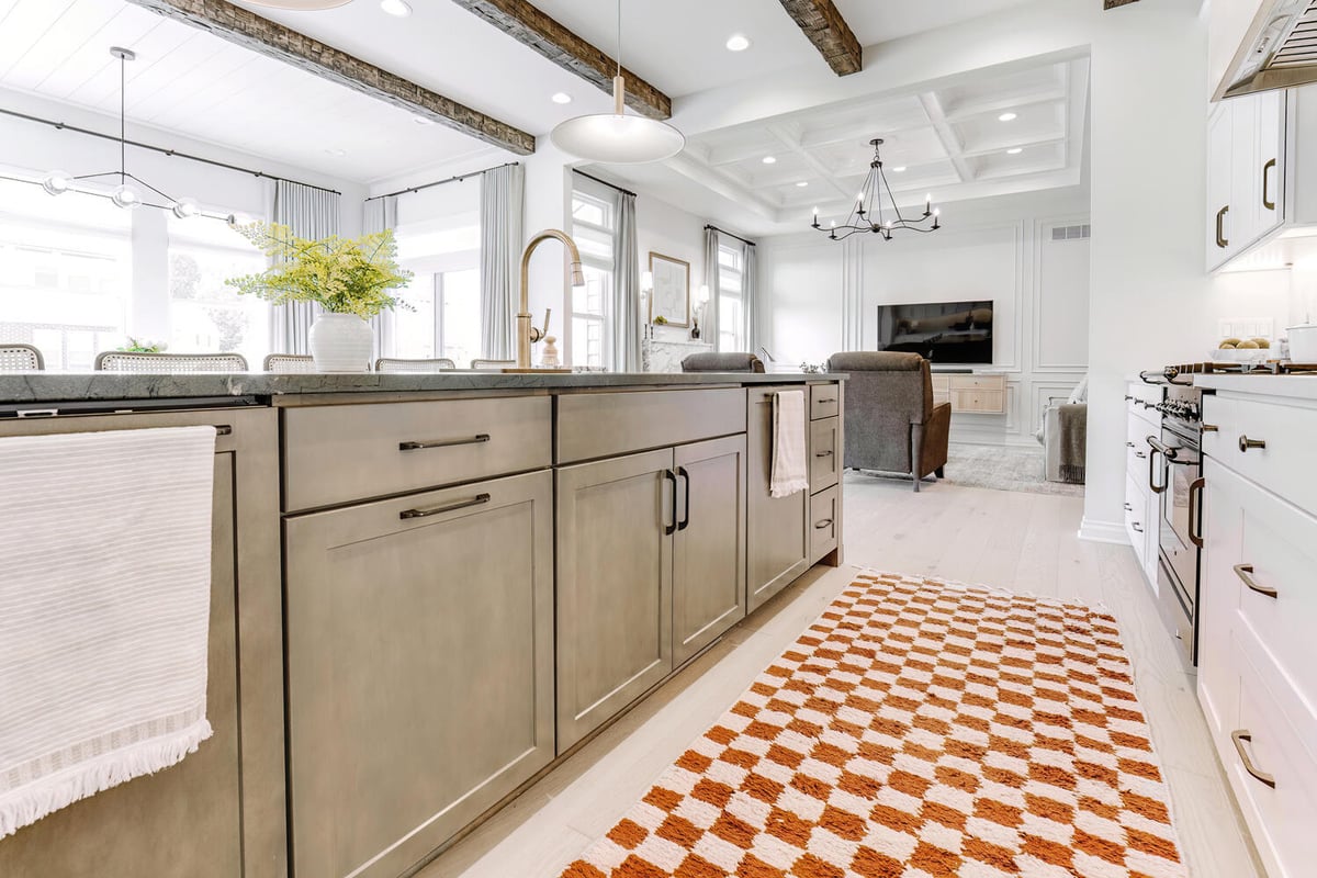 Open concept kitchen and living space featuring rustic beams and modern finishes in a custom home by Cabinet Creations, Oakland County, MI