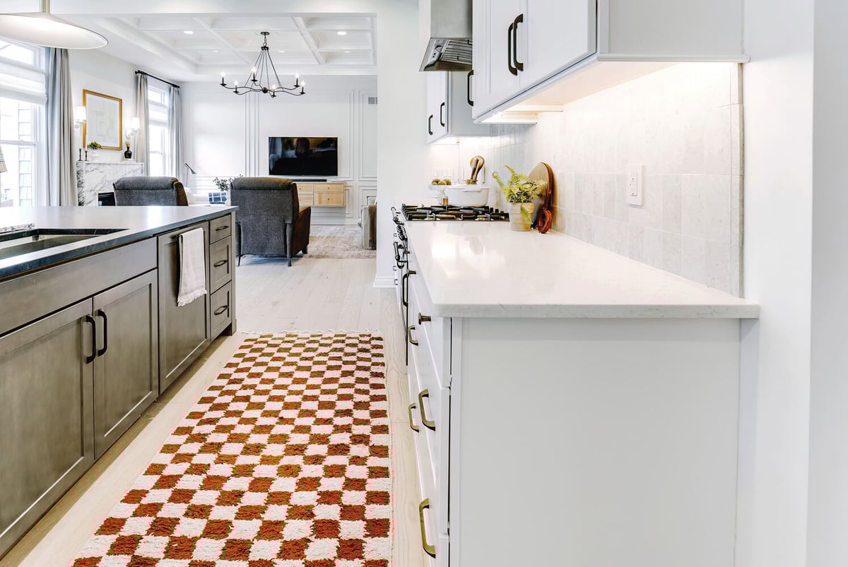Open kitchen with white cabinetry and red patterned runner in Waterford Township, MI