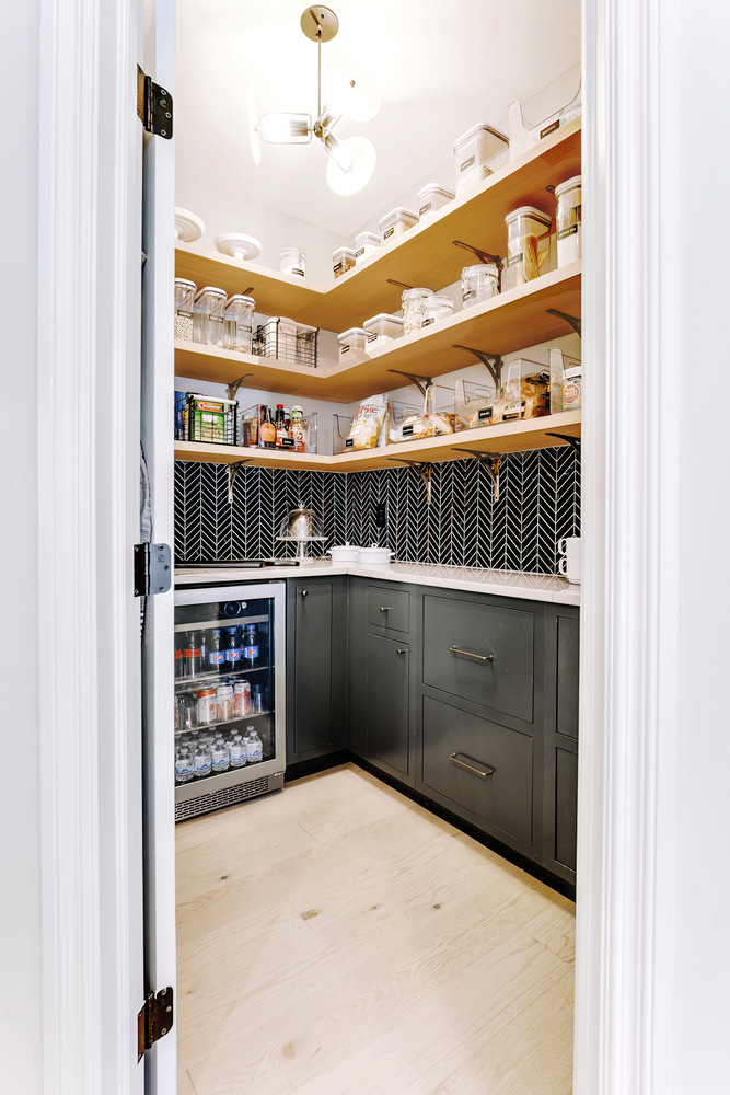 Walk-in pantry with glass-front beverage fridge and custom shelving by Cabinet Creations in Oakland County, MI