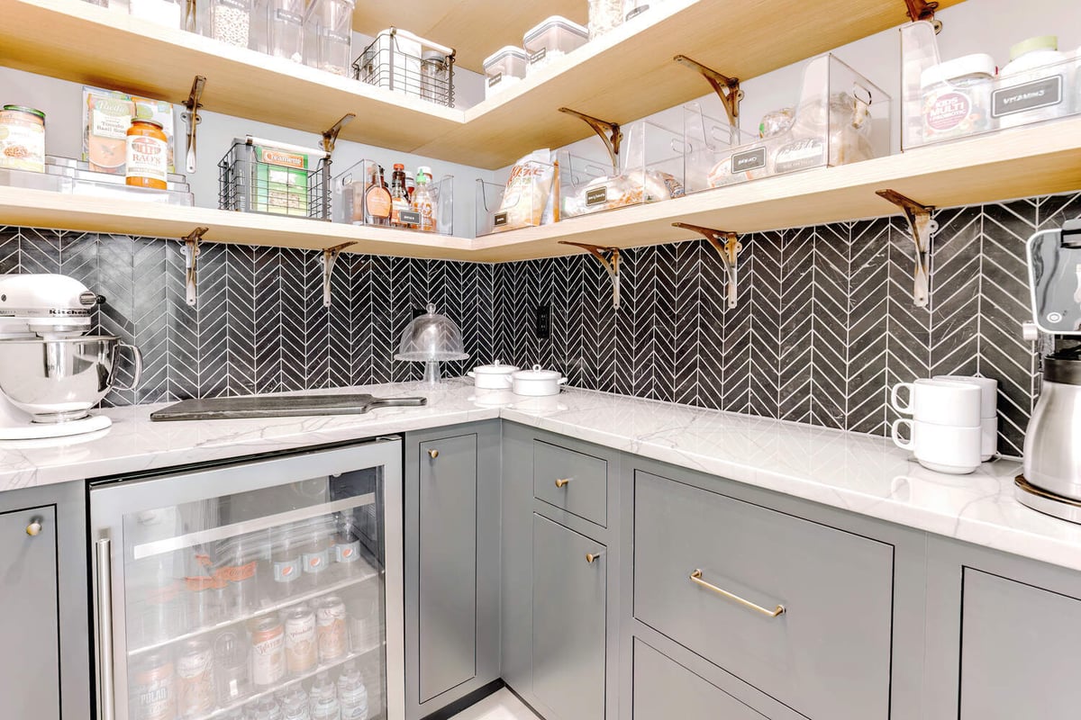 Walk-in pantry with gray cabinetry and black tile backsplash by Cabinet Creations in Oakland County, MI