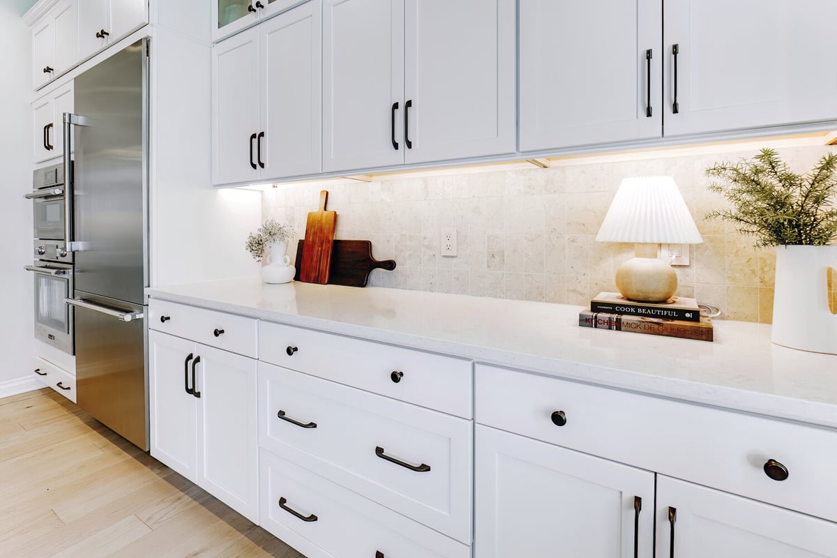 White shaker kitchen with cookbooks and ceramic lamp styling by Cabinet Creations in Keego Harbor, MI