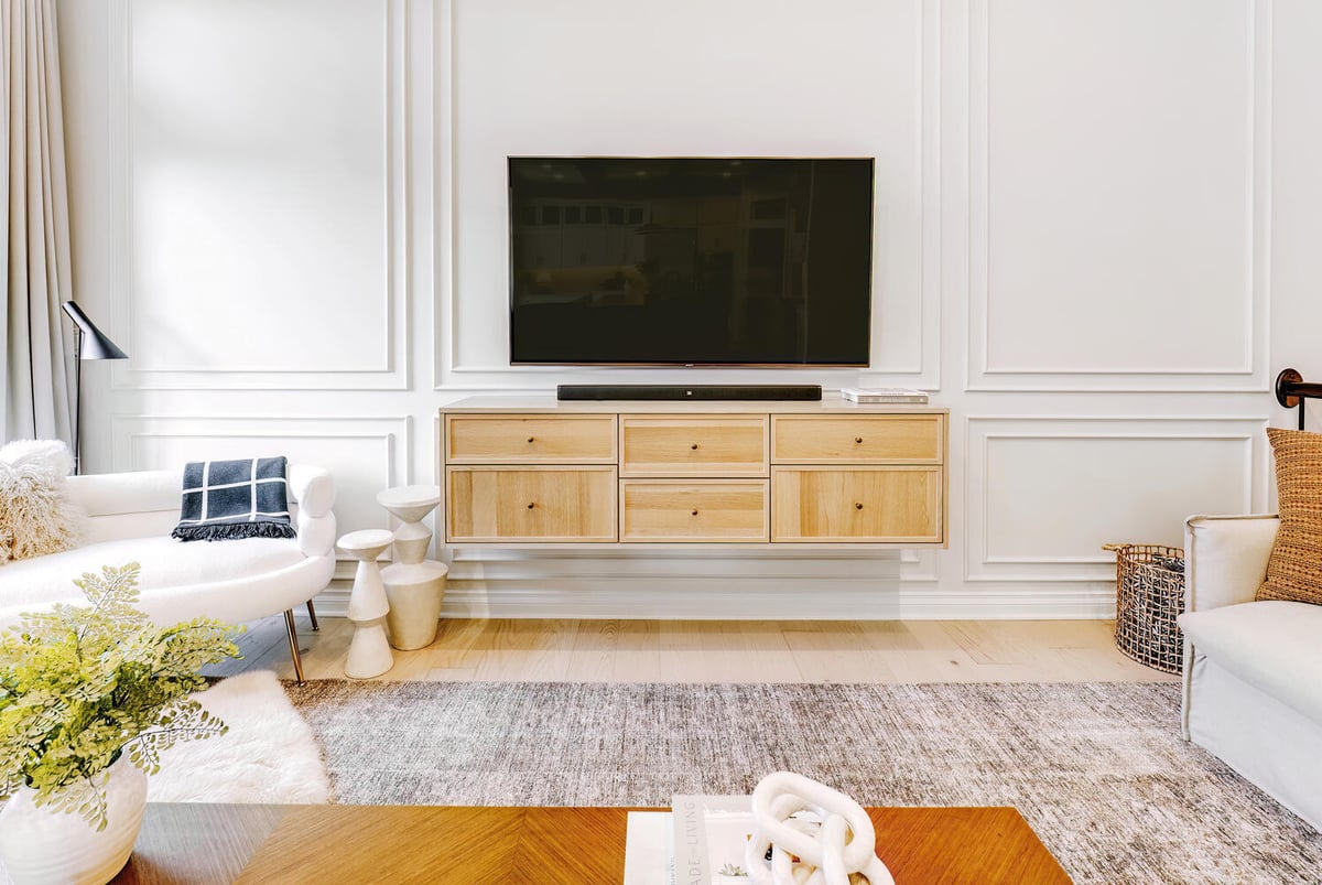 Built-in media wall with mounted TV and light wood cabinetry by Cabinet Creations in Oakland County, MI