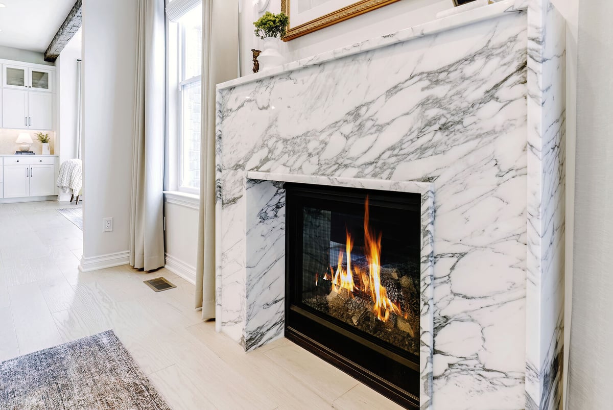 Close-up of marble fireplace surround with gas flames by Cabinet Creations in Oakland County, MI