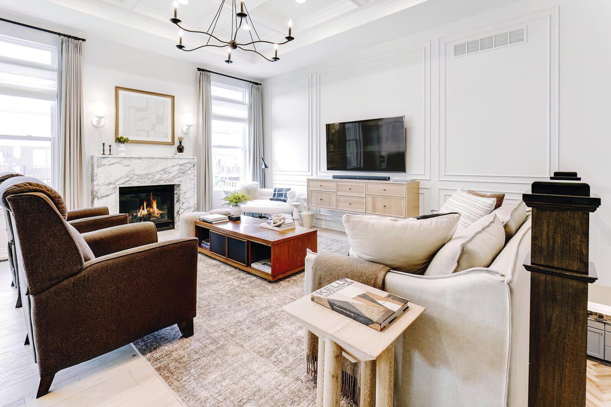 Living room with burning fireplace and mounted TV in a custom home by Cabinet Creations in Oakland County, MI