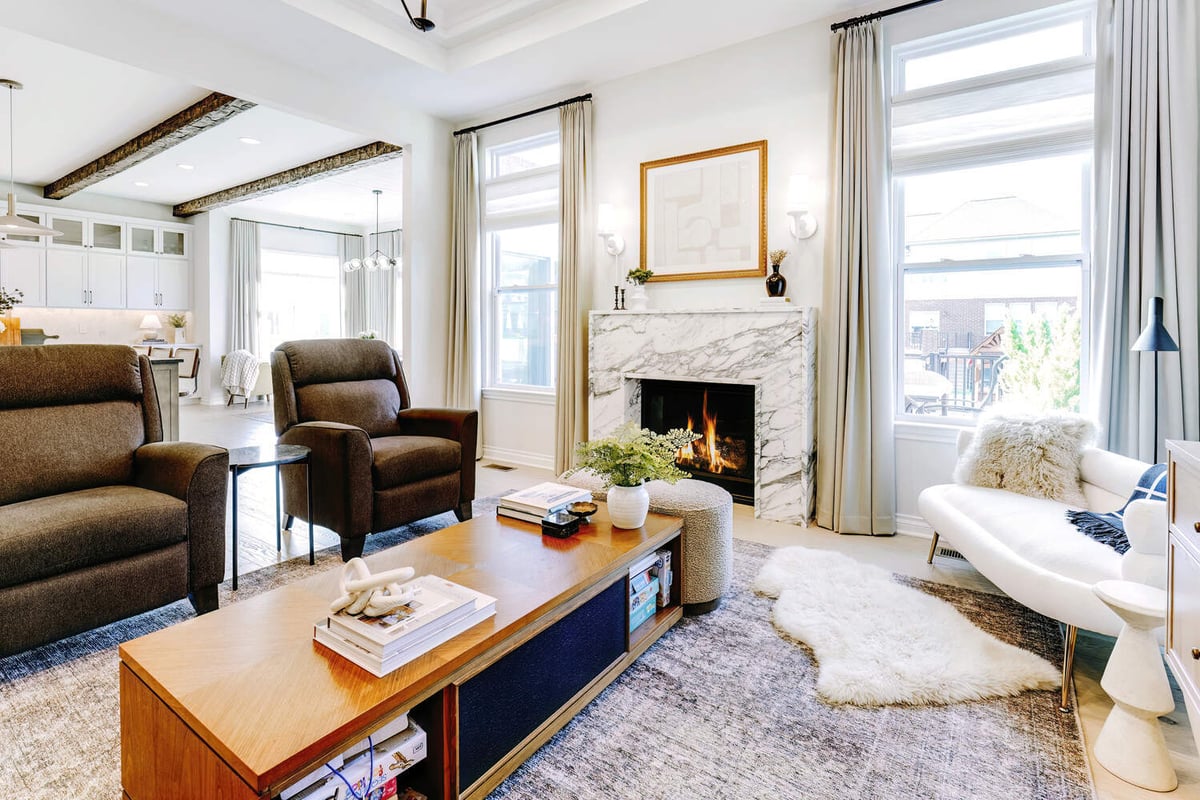 Living room with cozy fireplace and white curtain backdrop by Cabinet Creations in Oakland County, MI