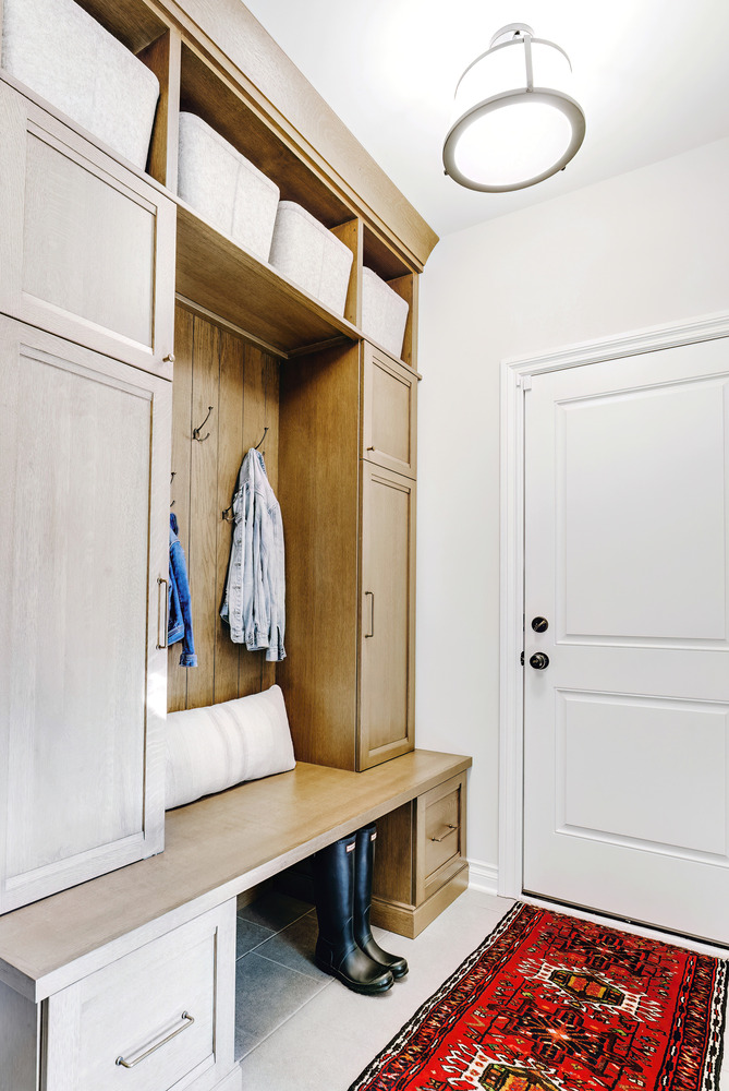 Built-in mudroom bench with upper cubbies and wood cabinetry by Cabinet Creations in a custom home in Waterford Township, MI