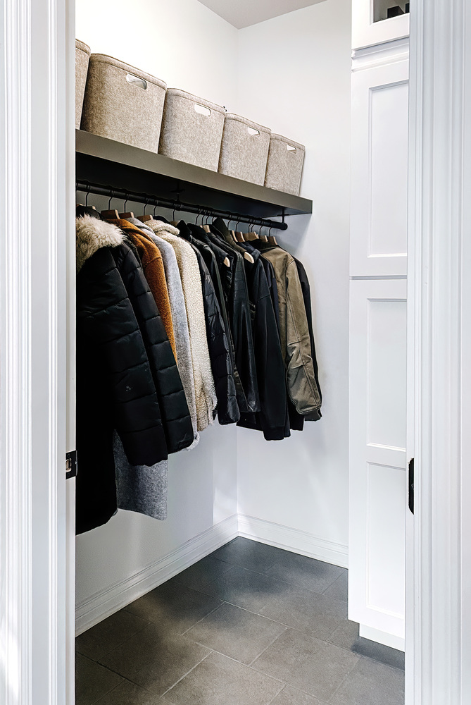 Lined coat storage in a modern custom mudroom with open bin shelving by Cabinet Creations in Oakland County