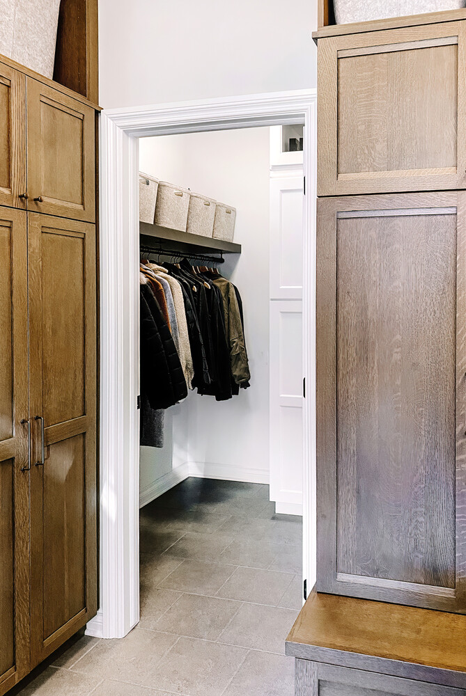 Organized entry closet with hanging rod and cubbies in a Waterford Township home by Cabinet Creations