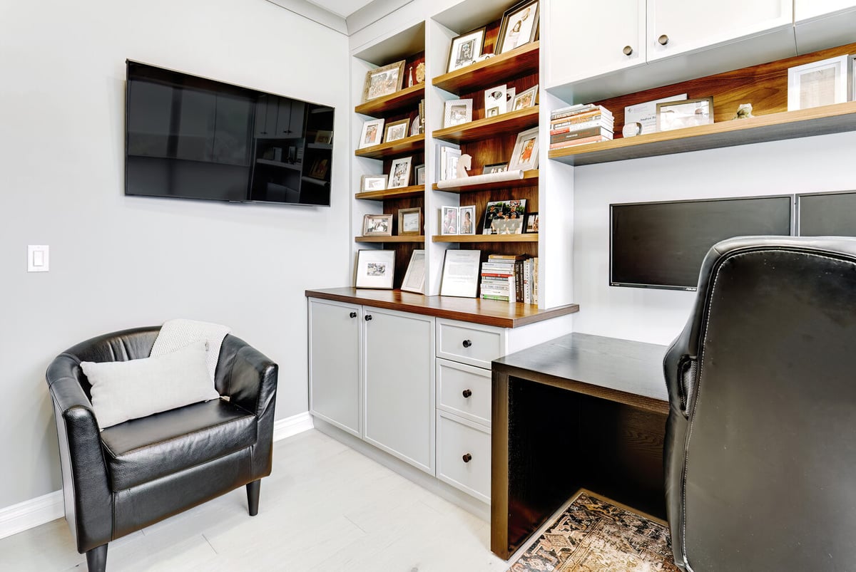 Comfortable workspace with mounted TV and custom shelving in a custom Michigan home