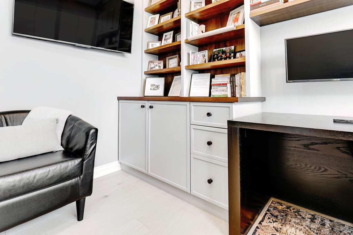 Integrated home office cabinetry and desk with media setup in a Michigan custom home by Cabinet Creations