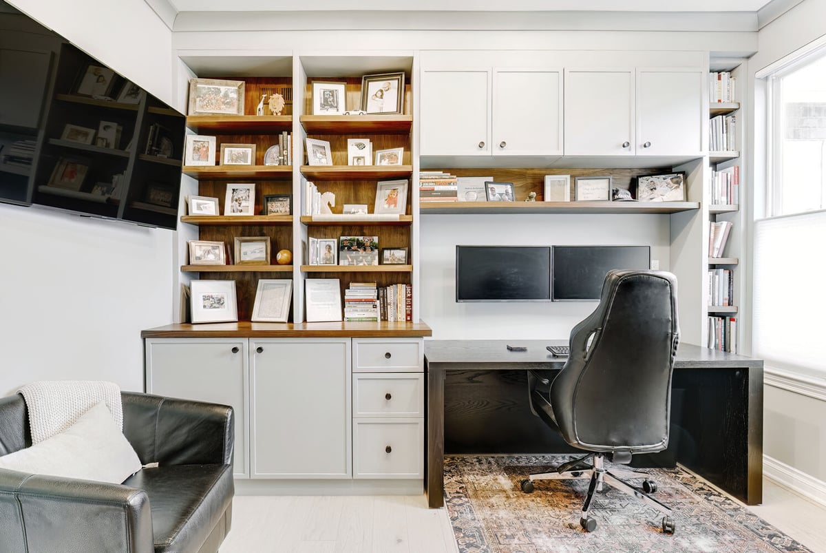 Modern home office with dual monitors, floating shelves, and custom cabinetry by Cabinet Creations in Michigan