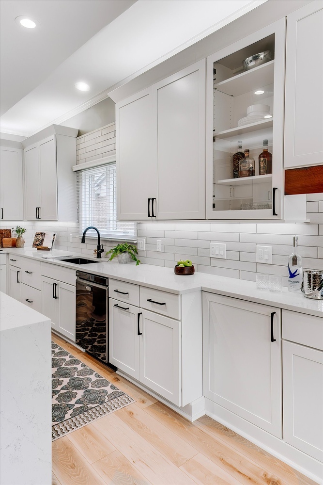 Bright custom kitchen in Birmingham, MI by Cabinet Creations showcasing white cabinets, subway tile backsplash, and black accents