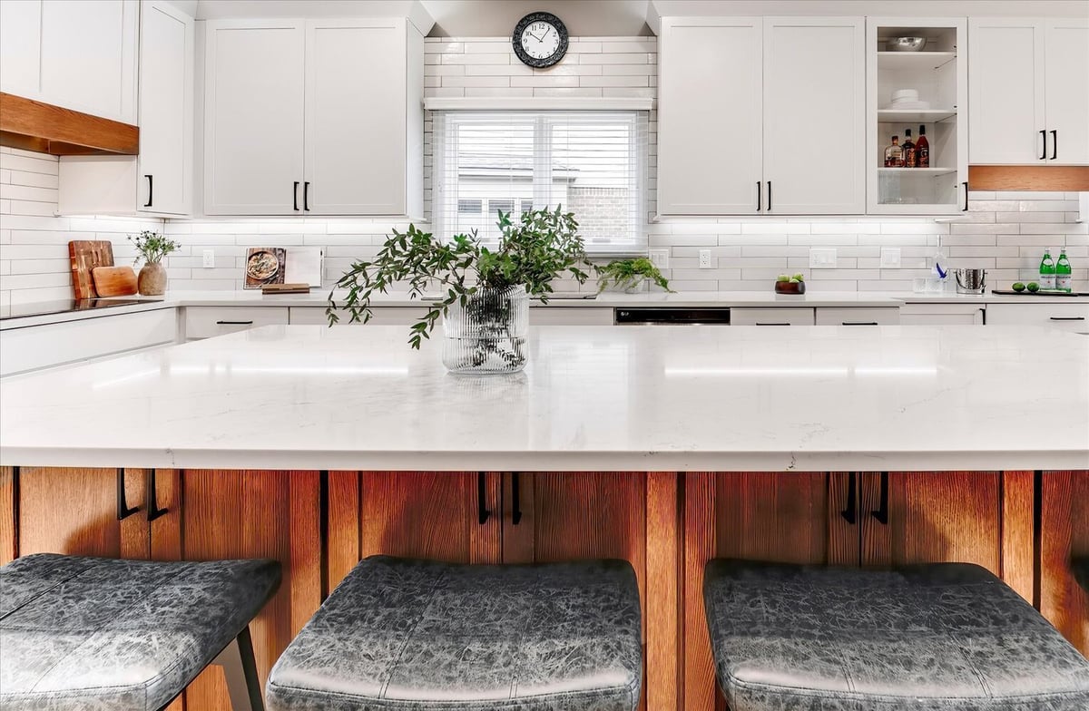 Bright kitchen island with quartz waterfall edge in a custom home by Cabinet Creations, Oakland County