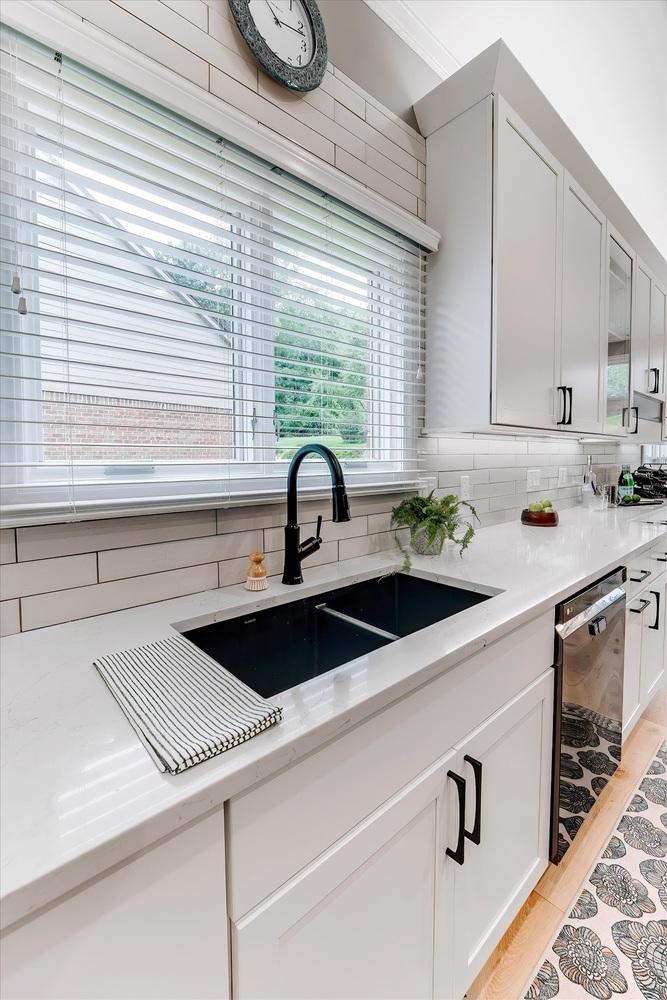 Close-up of a black undermount sink and white quartz countertops in a custom kitchen by Cabinet Creations