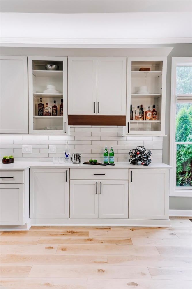 Custom kitchen bar setup with built-in storage and glass shelving by Cabinet Creations in Oakland County, MI
