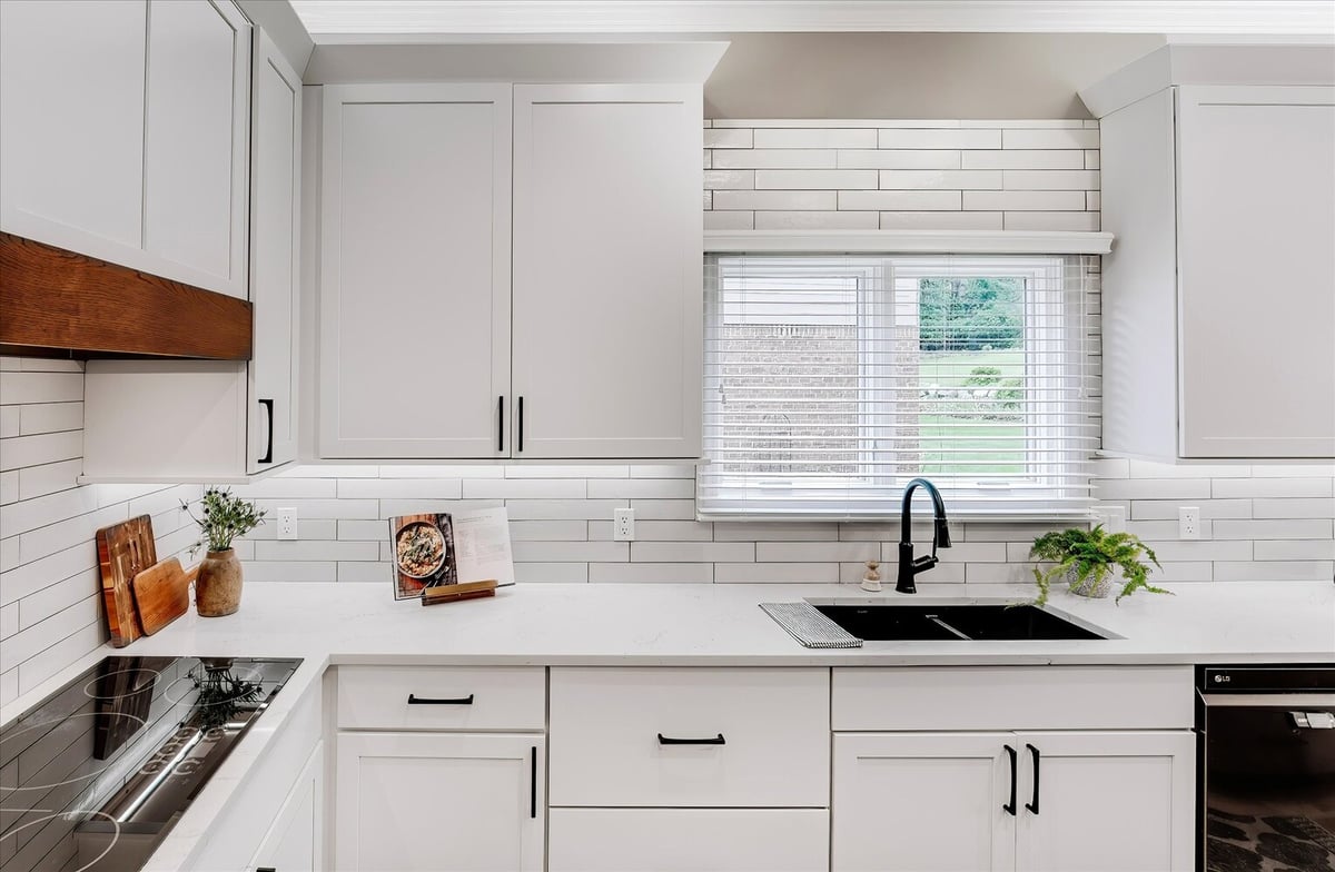 Custom sink wall with black faucet and quartz countertops in Michigan home by Cabinet Creations