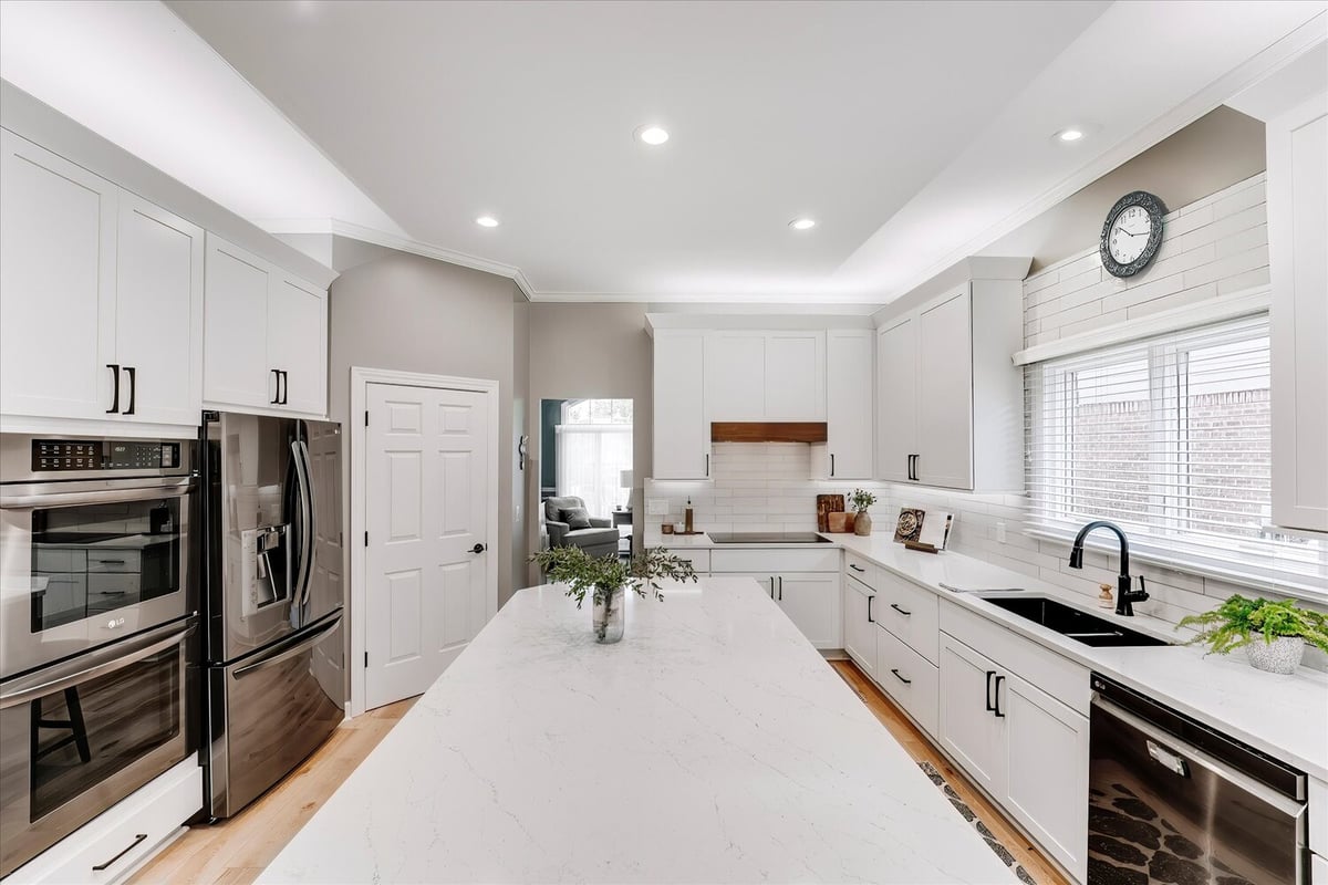 Full kitchen view with quartz island and black sink by Cabinet Creations in Michigan custom home