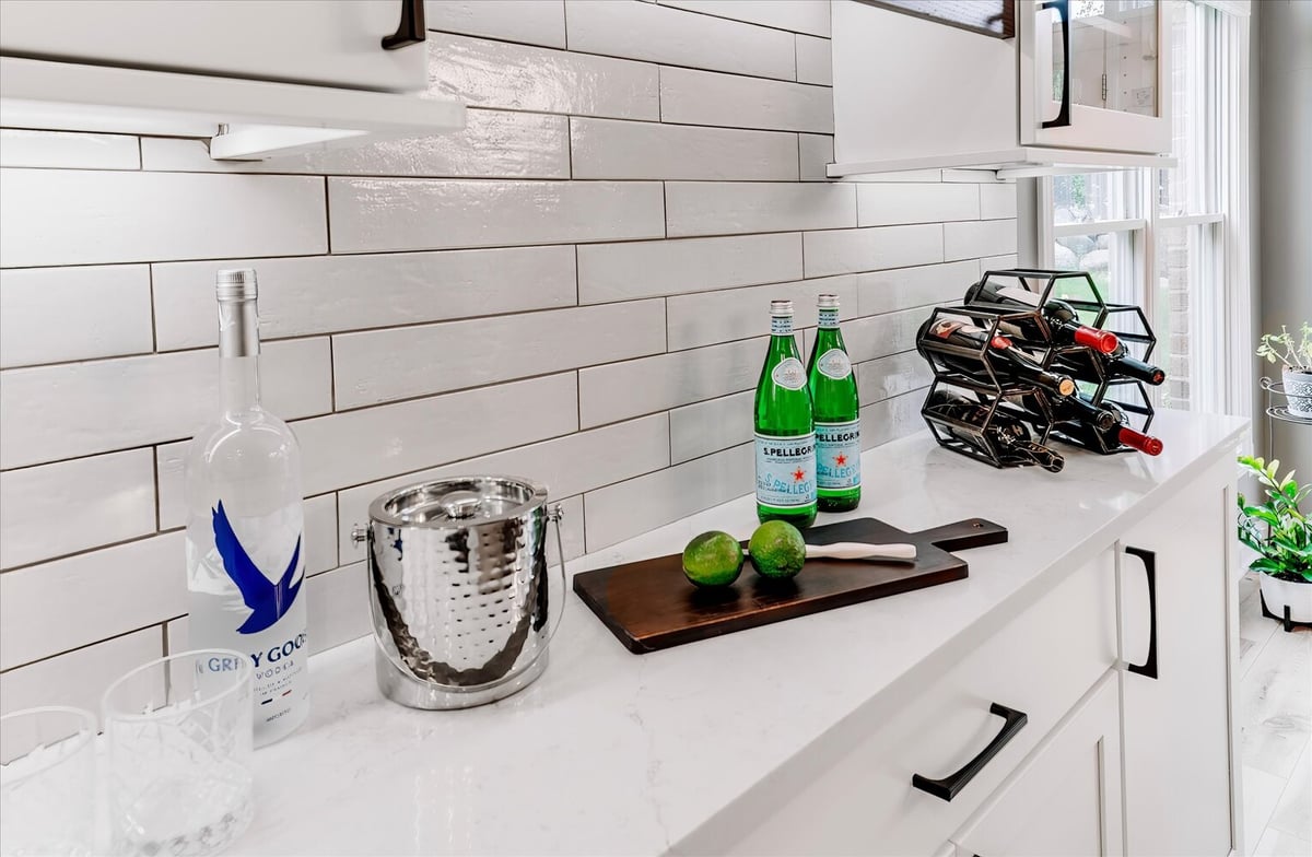 Kitchen beverage bar setup with Grey Goose, San Pellegrino, and wine rack by Cabinet Creations