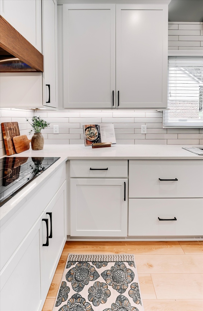 Kitchen corner with white shaker drawers and a cookbook stand in a Michigan home by Cabinet Creations