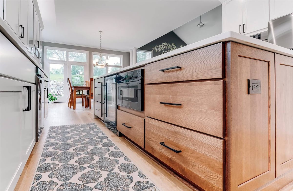 Modern kitchen walkway leading to dining area in a custom home by Cabinet Creations in Oakland County