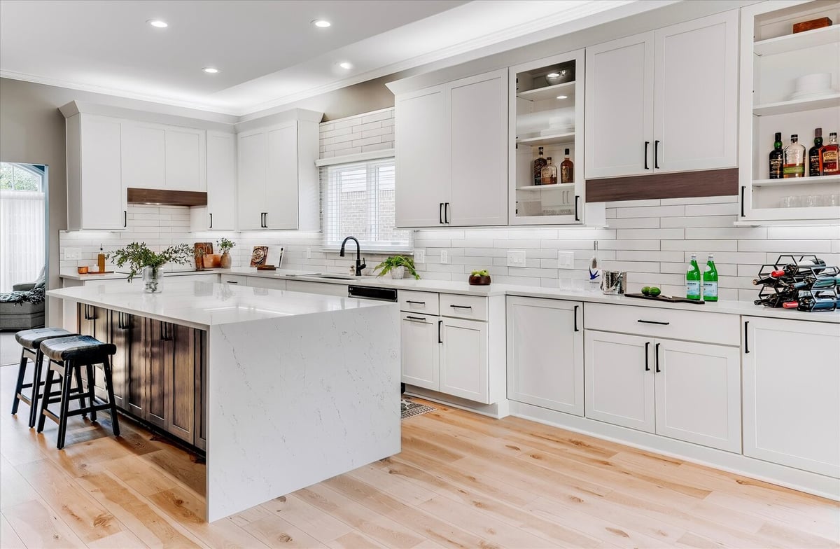 Spacious custom kitchen with waterfall island and white cabinetry by Cabinet Creations in West Bloomfield Township, MI