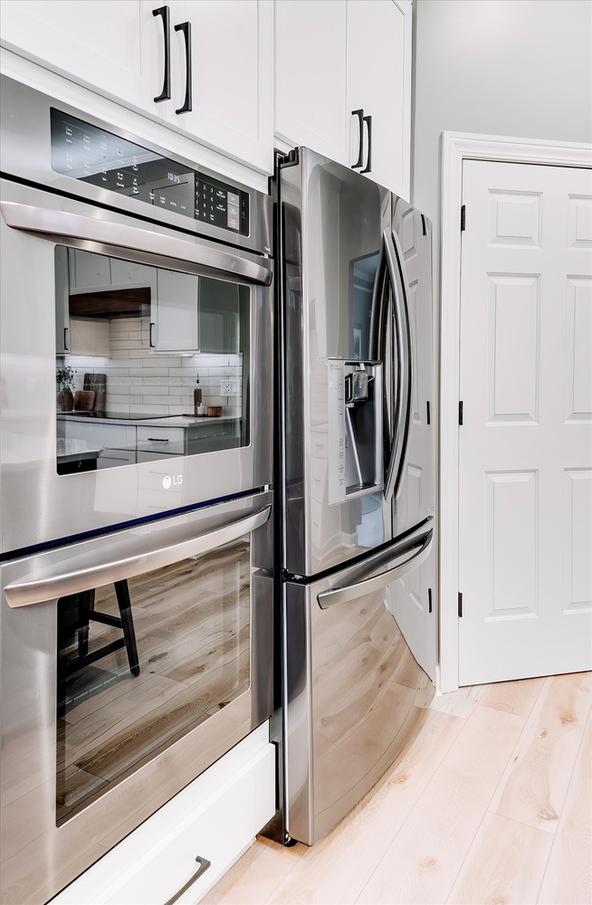 Stainless steel double oven and French door refrigerator in a custom kitchen by Cabinet Creations in Troy, MI