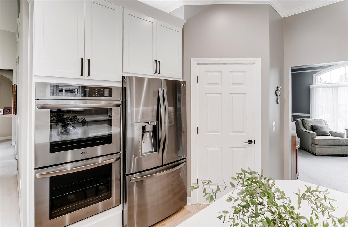 Stainless steel double oven and French door refrigerator in a custom kitchen by Cabinet Creations