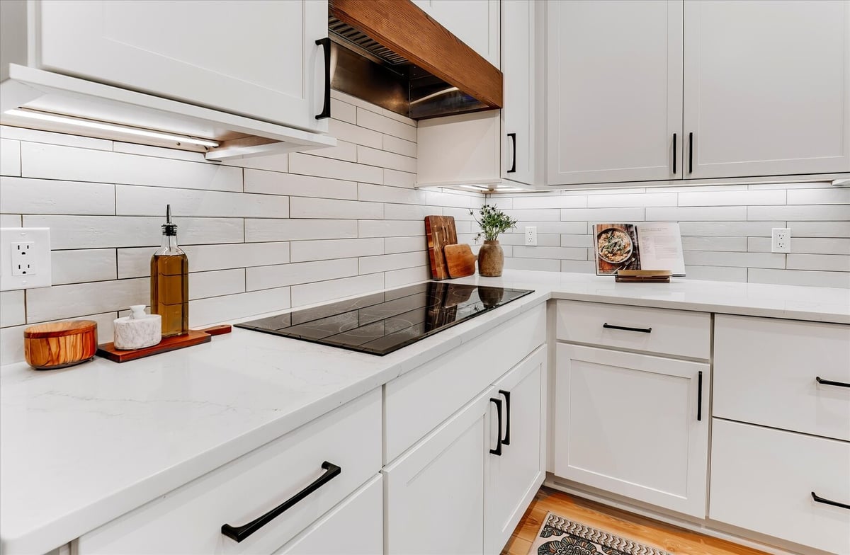 White subway tile backsplash and built-in cooktop in a custom kitchen by Cabinet Creations, Michigan