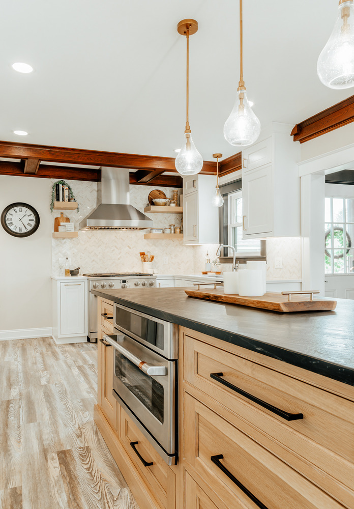 Custom kitchen design in Lake Orion, MI by Cabinet Creations featuring wood island cabinetry and black quartz countertops