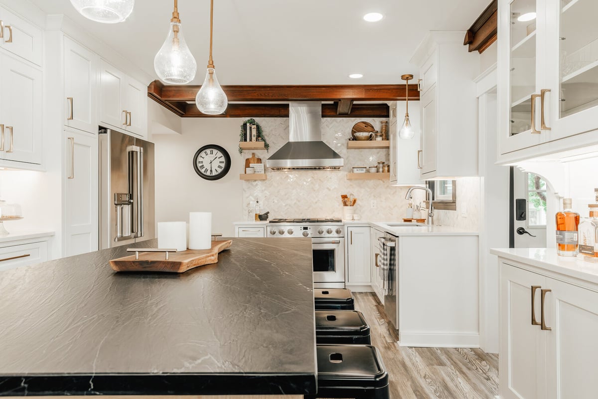 Lake Orion custom home kitchen with wood island and tufted dining chairs by Cabinet Creations