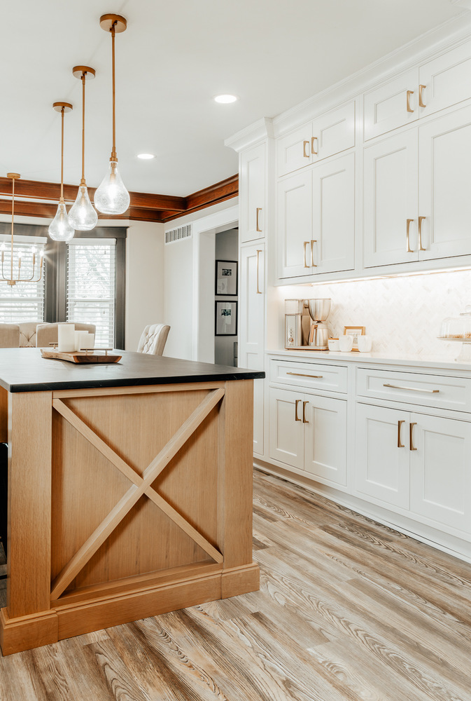 Lake Orion kitchen with white cabinets, black island top, and stainless steel refrigerator by Cabinet Creations