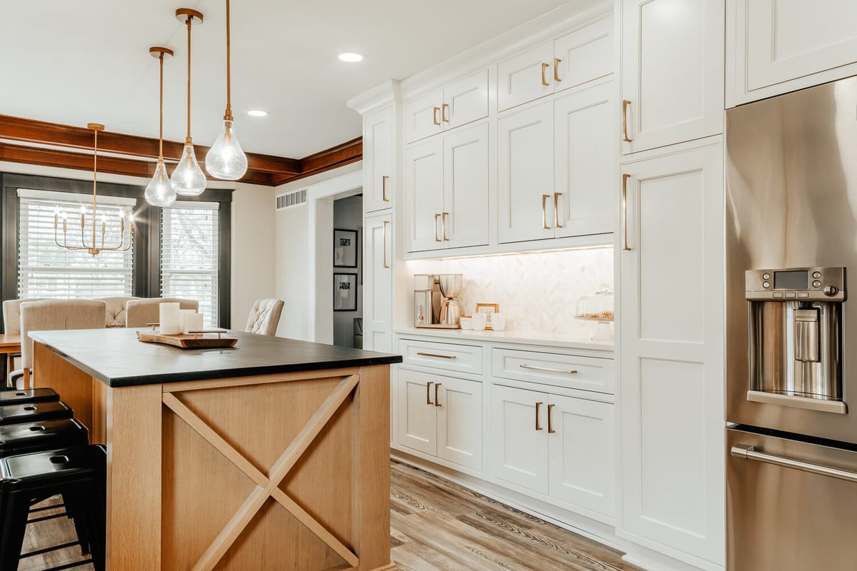 Modern custom kitchen in Lake Orion, MI by Cabinet Creations featuring white shaker cabinets and wood island with black countertop